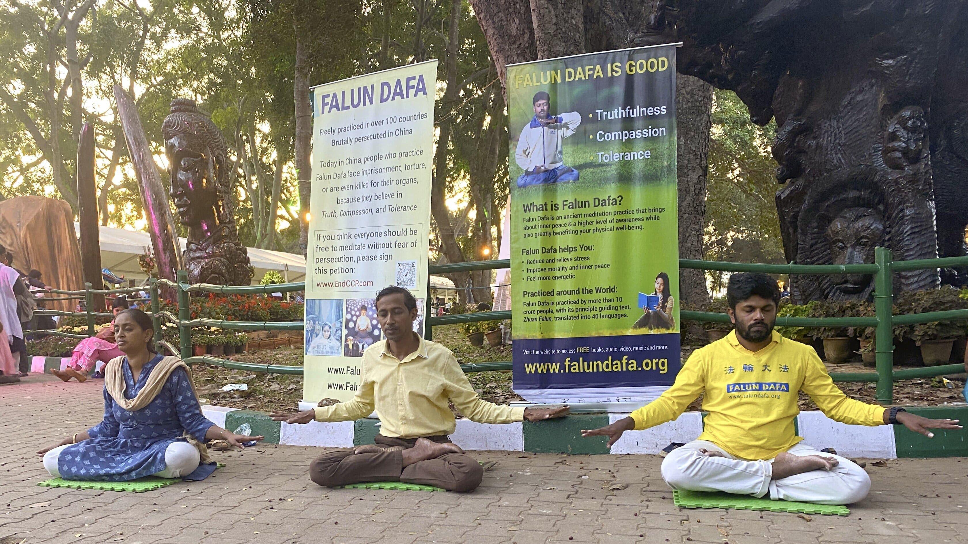 Falun Gong practitioners in Bangalore meditate and offer instruction to passerby at the 213th annual flower show.