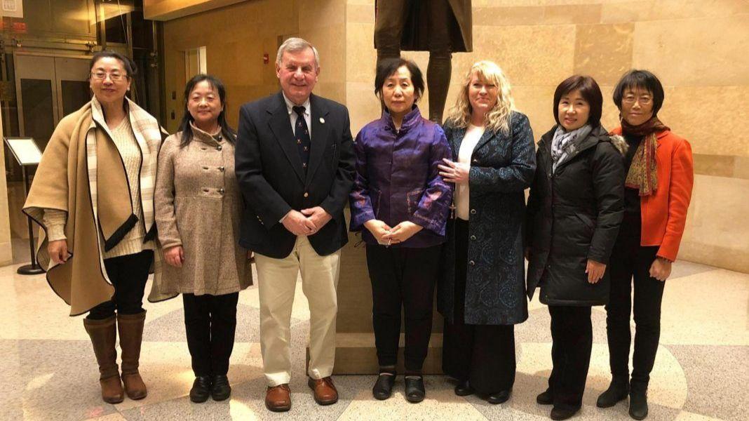 John Avoili stands next to local Falun Gong practitioners in Virginia.